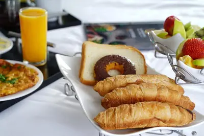 a plate of food with pastries and fruit on a table at Al Joude Hotel فندق الجود in Irbid