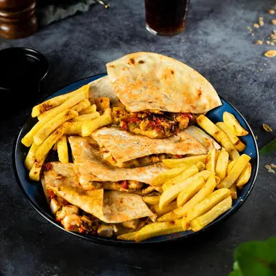 a plate of food with a sandwich and french fries at Al Joude Hotel فندق الجود in Irbid