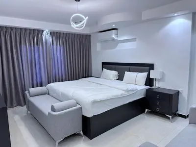 a bedroom with a large bed and a chair at Al Joude Hotel فندق الجود in Irbid