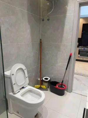 a bathroom with a toilet and two mop at Oqdeh Delux Apartments in Jerash