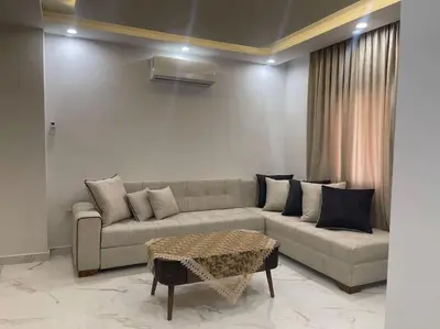 a living room with a couch and a table at Oqdeh Delux Apartments in Jerash