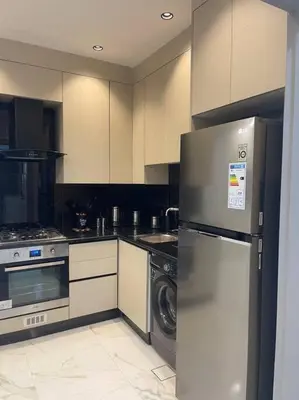 a kitchen with a stainless steel refrigerator and a dishwasher at Oqdeh Delux Apartments in Jerash