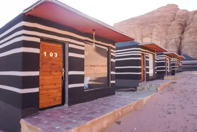 a row of houses in front of a mountain at Mirage Camp Wadi Rum in Wadi Rum