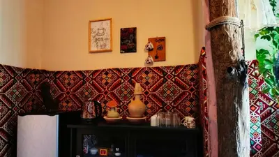 a corner of a room with a wall covered in tiles at Grandma's house in Wadi Musa