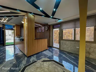 a lobby of a building with a clock on the wall at Pretal Hotel in Al Mafraq