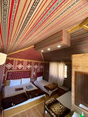 a bedroom with two beds and a red ceiling at Wadi Rum Spring Moon & Jeep Tour in Wadi Rum