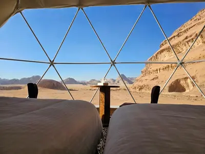 two beds in a tent with a view of the desert at Sun Luxury Rum Camp in Wadi Rum