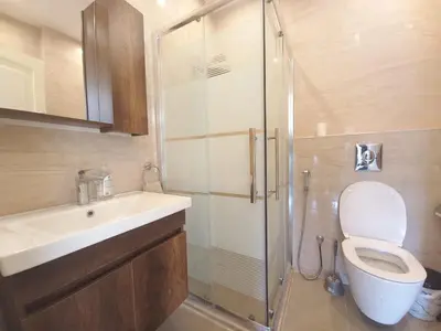 a bathroom with a shower and a toilet and a sink at Shmeisani homes central location near Abdali in Amman