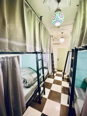 a room with two bunk beds on a checkered floor at Friends Oasis in Aqaba