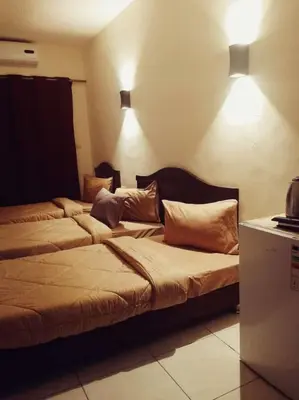 two beds in a room with lights on the wall at Amir Palace Hotel in Aqaba