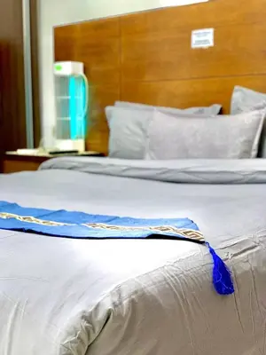 a white bed with a blue ribbon on it at Amir Palace Hotel in Aqaba