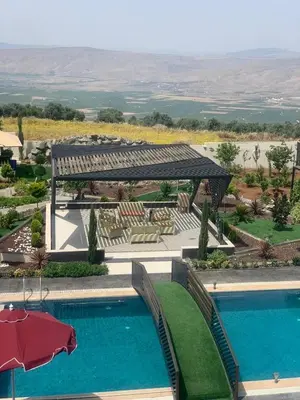 a resort with a swimming pool and an umbrella at Kinda vip in Al Mashāriqah