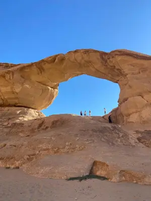 people standing under an arch on the beach at Bilal luxury camp in Wadi Rum