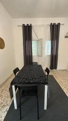 a table and chairs in a room with a window at Turkuaz Aparment in Amman