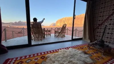 a person sitting in a chair looking out at the desert at Bedouin Nature Camp in Wadi Rum