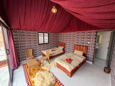 a bedroom with a bed and a table and chairs at Bedouin Nature Camp in Wadi Rum