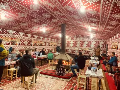 a group of people sitting at tables in a restaurant at Milk way desert in Wadi Rum