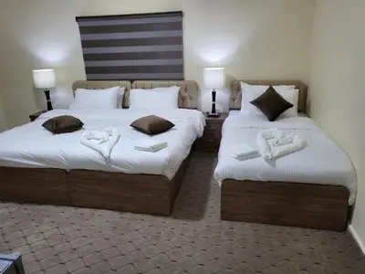 two beds in a room with white towels on them at Petra Hills House in Wadi Musa