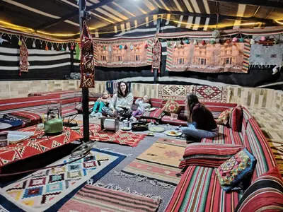 a group of people sitting in a room filled with carpets at Petra Magic Guest House in Wadi Musa