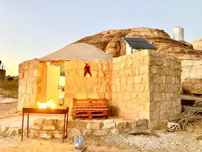 a stone building with a bench in front of it at Pink city cottage in Wadi Musa