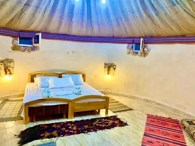 a bedroom with a bed with a canopy at Pink city cottage in Wadi Musa