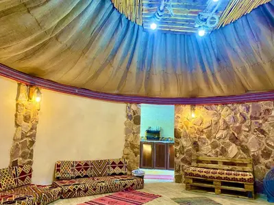 a room with a stage with curtains and benches at Pink city cottage in Wadi Musa