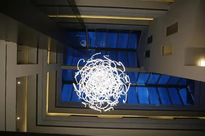 a lit chandelier in front of a window at Kaya Hotel Amman in Amman