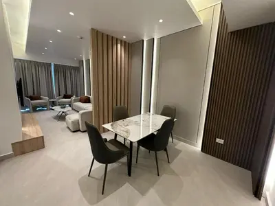 a room with a table and chairs and a living room at Damac Tower Amman Luxury Apartments - استوديوهات وشقق فاخرة - داماك عمان العبدلي in Amman