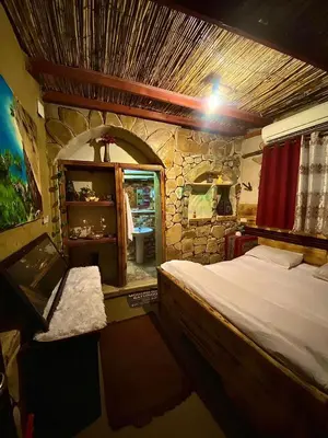 a bedroom with a bed and a stone wall at My Grandfathers House Dana Heritage and Eco Lodge in Dana
