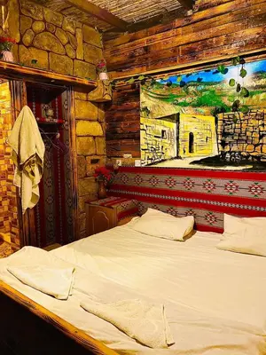 a bed in a room with a painting on the wall at My Grandfathers House Dana Heritage and Eco Lodge in Dana