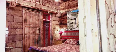 a bedroom with a bed in a stone wall at My Grandfathers House Dana Heritage and Eco Lodge in Dana