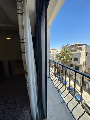 a balcony with white umbrellas on a building at modern 2bedroom for rent Abdoun in Amman