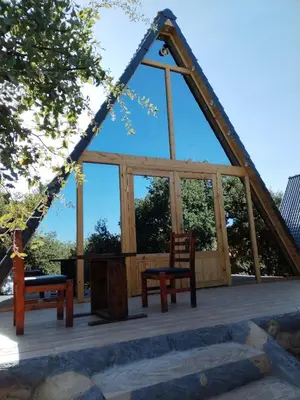 a gazebo with two chairs and benches on a deck at Widian al-sham huts in Jerash