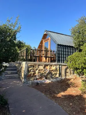 a home with a stone retaining wall and a house at Widian al-sham huts in Jerash