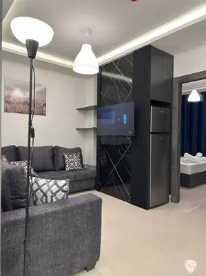 a living room with a couch and a tv at modern 2bedroom for rent abdoun2 in Amman