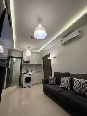a living room with a couch and a kitchen at modern 2bedroom for rent abdoun2 in Amman