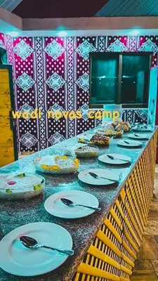 a buffet line with white plates and utensils on it at wadi novas camp in Wadi Rum