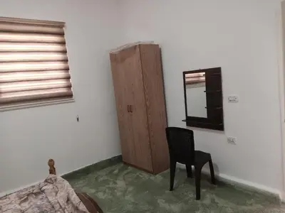 a bedroom with a chair and a mirror and a window at petra sun apartment in Wadi Musa