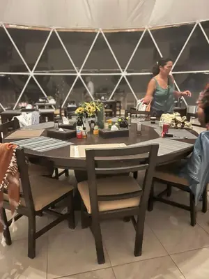 a woman standing at a table in a restaurant at Wadi Rum Rose Luxury camp in Wadi Rum