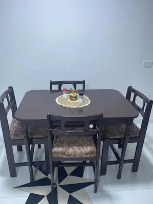 a black table with chairs and a plate of food on it at Beit Al Hasan بيت الحسن in Um Qeis
