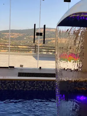 a water fountain next to a swimming pool at Souf view in Jerash