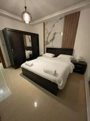 a bedroom with a large bed and a mirror at apartment 60m 1bedroom for rent2 in Umm Uthainah