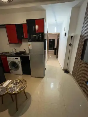 a kitchen with a refrigerator and a table in a room at apartment 60m 1bedroom for rent2 in Umm Uthainah