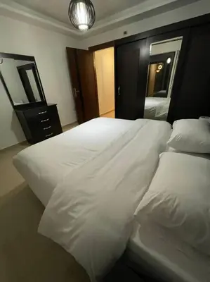 a bedroom with two white beds and a mirror at apartment 60m 1bedroom for rent3 in Umm Uthainah