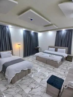 a bedroom with two beds and a marble floor at dream house hotel in Jerash
