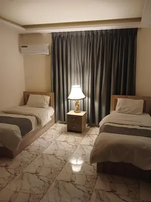 a hotel room with two beds and a lamp at dream house hotel in Jerash