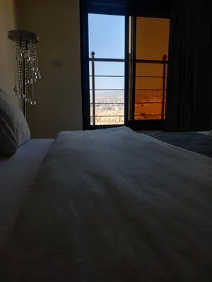 a bedroom with a large white bed with a window at dream house hotel in Jerash