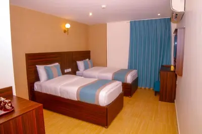 a hotel room with two beds and a window at ِAfnan hotel in Aqaba