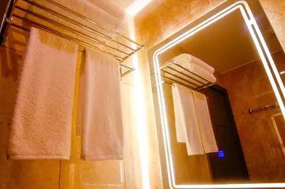 a bathroom with a mirror and a shower with towels at ِAfnan hotel in Aqaba