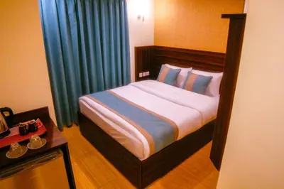 a bedroom with a large bed with blue curtains at ِAfnan hotel in Aqaba